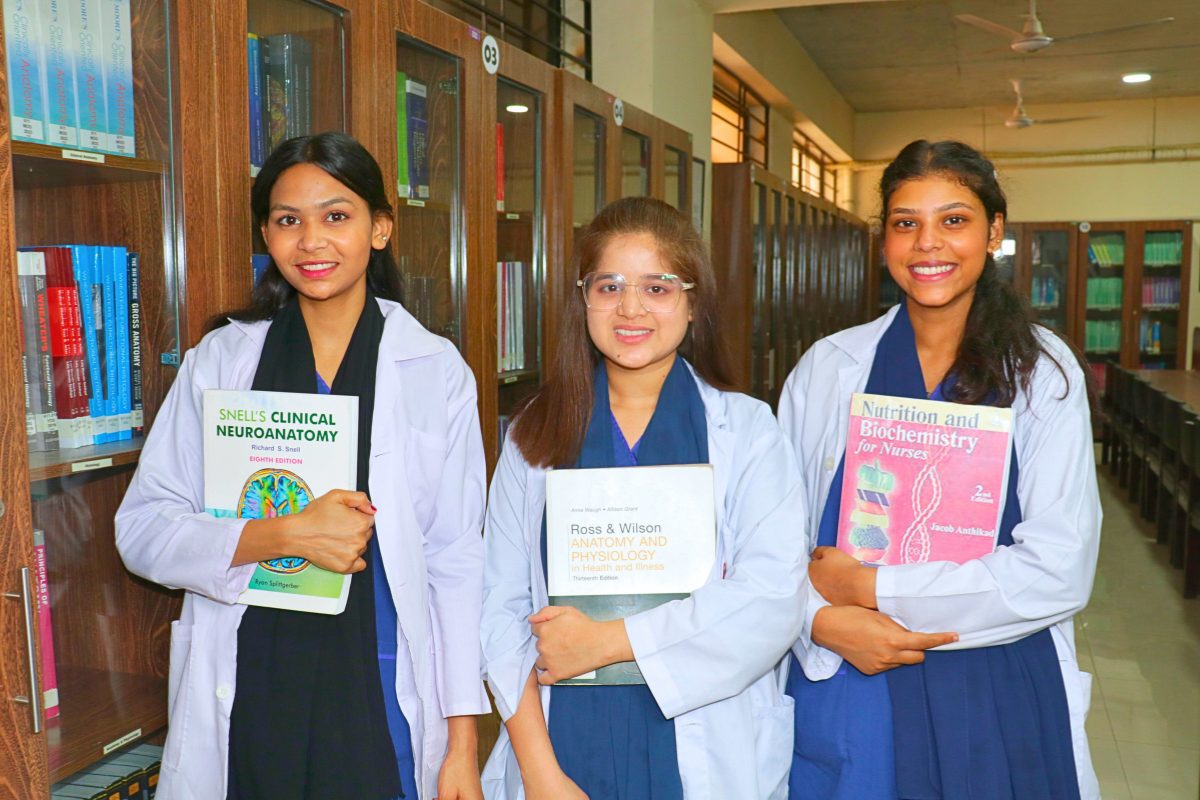Three girl students holding books in their hands and smiling in Kulsum Institute of Health Sciences